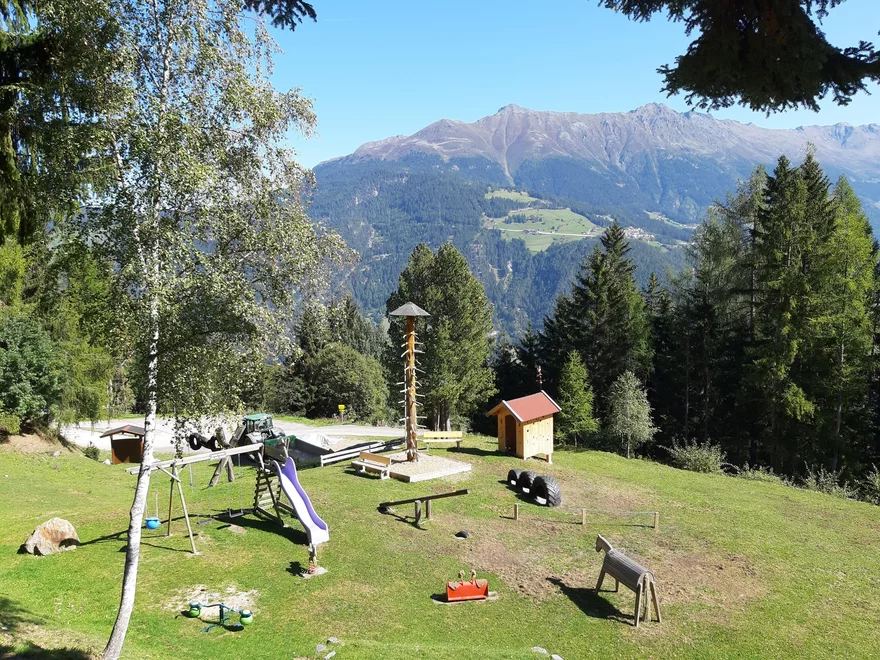 Abenteuerspielplatz mit Schaukel, Rutsche und Wippe auf einer Bergwiese mit Panoramablick in Serfaus-Fiss-Ladis