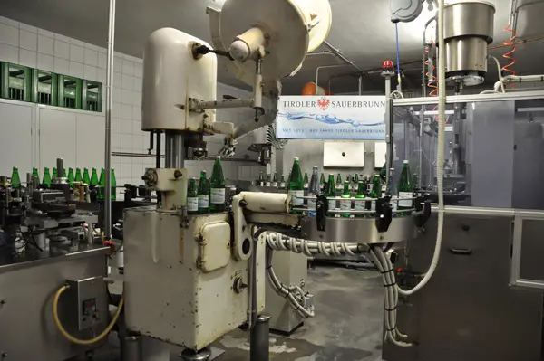 Abfüllanlage des Tiroler Sauerbrunn mit grünen Glasflaschen auf dem Förderband