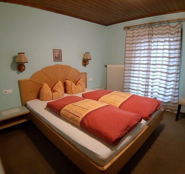 Schlafzimmer mit Doppelbett aus Holz in Appartement 2 der Pension Obladis