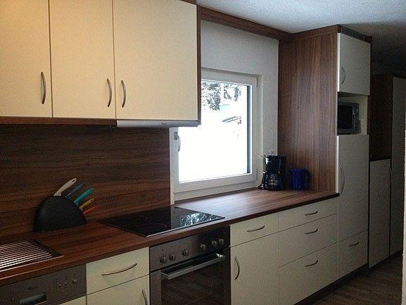 Wohnküche mit dunkler Arbeitsplatte und Fenster in Appartement 3