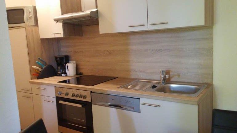 Wohnküche mit heller Holzfront in Appartement 5