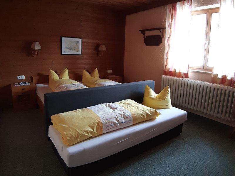 Holzvertäfeltes Schlafzimmer mit Doppelbett und Zustellbett in Appartement 7 der Pension Obladis