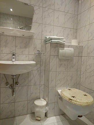 Badezimmer mit Waschbecken, Spiegel und frischen Handtüchern im Doppelzimmer der Pension Obladis