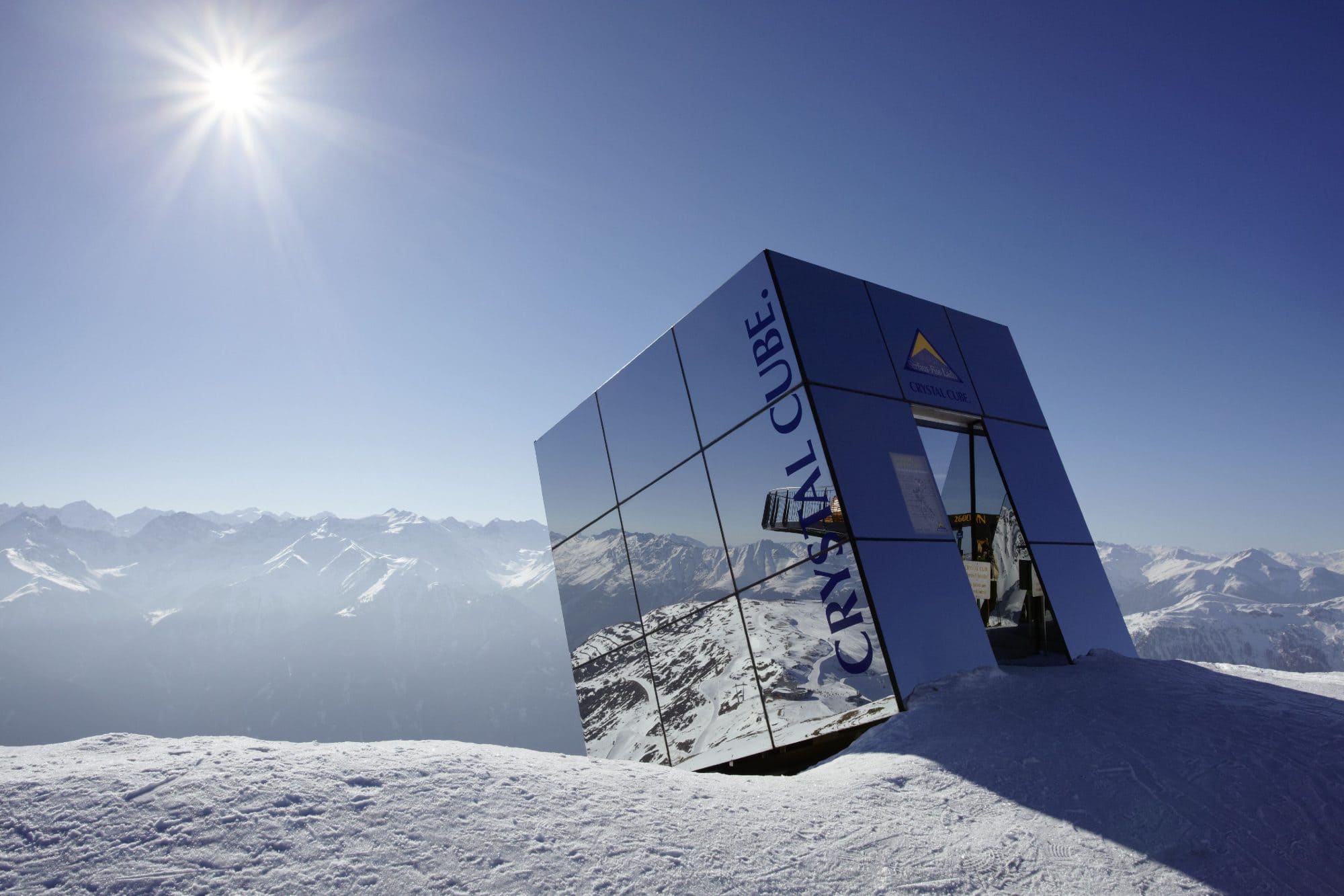 Der verspiegelte Crystal Cube am Gipfel im Skigebiet Serfaus-Fiss-Ladis vor verschneitem Alpenpanorama