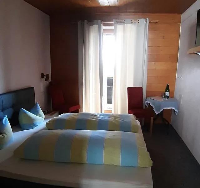 Helles Doppelzimmer mit Balkontür der Pension Obladis