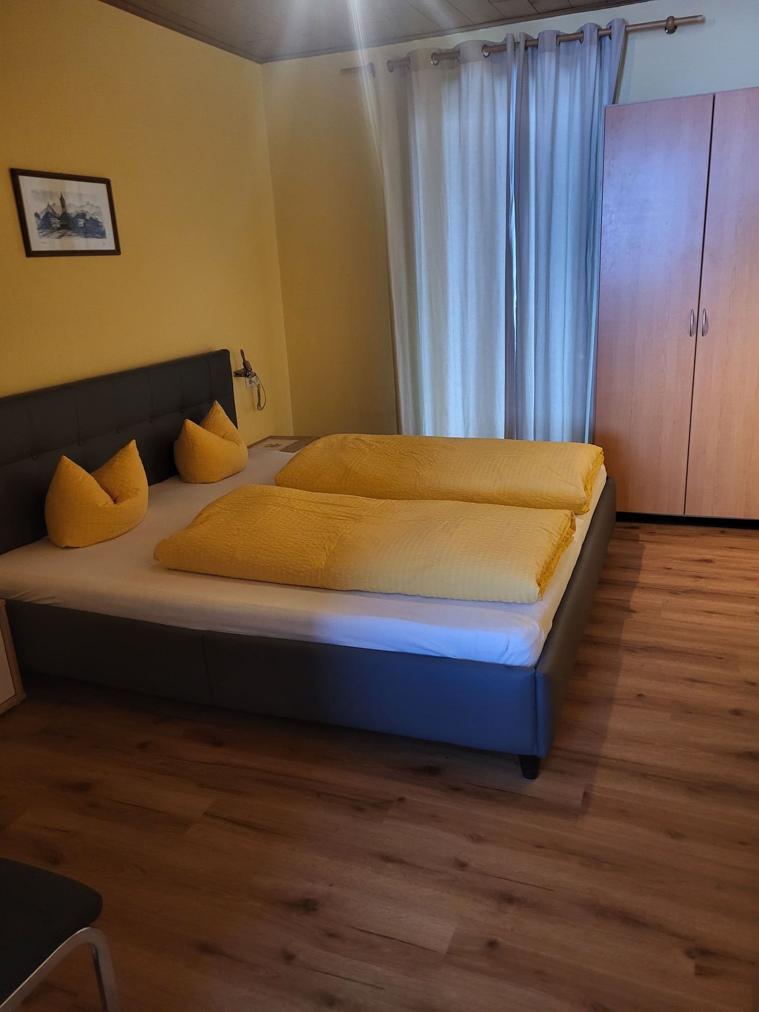 Doppelzimmer mit Holzboden und gemütlichem Doppelbett in der Pension Obladis
