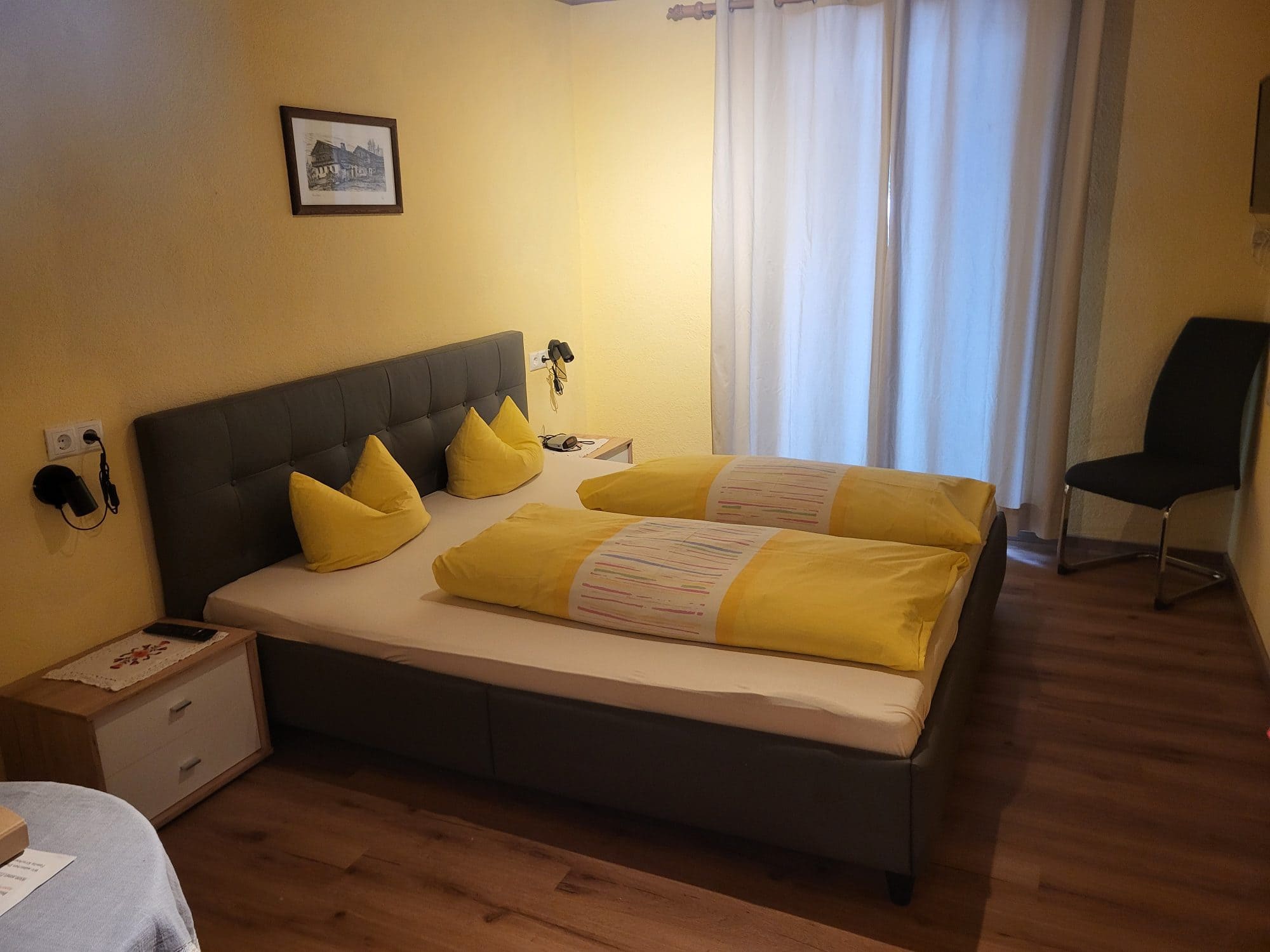 Gemütliches Doppelzimmer der Pension Obladis mit Holzboden und warmen Wandtönen