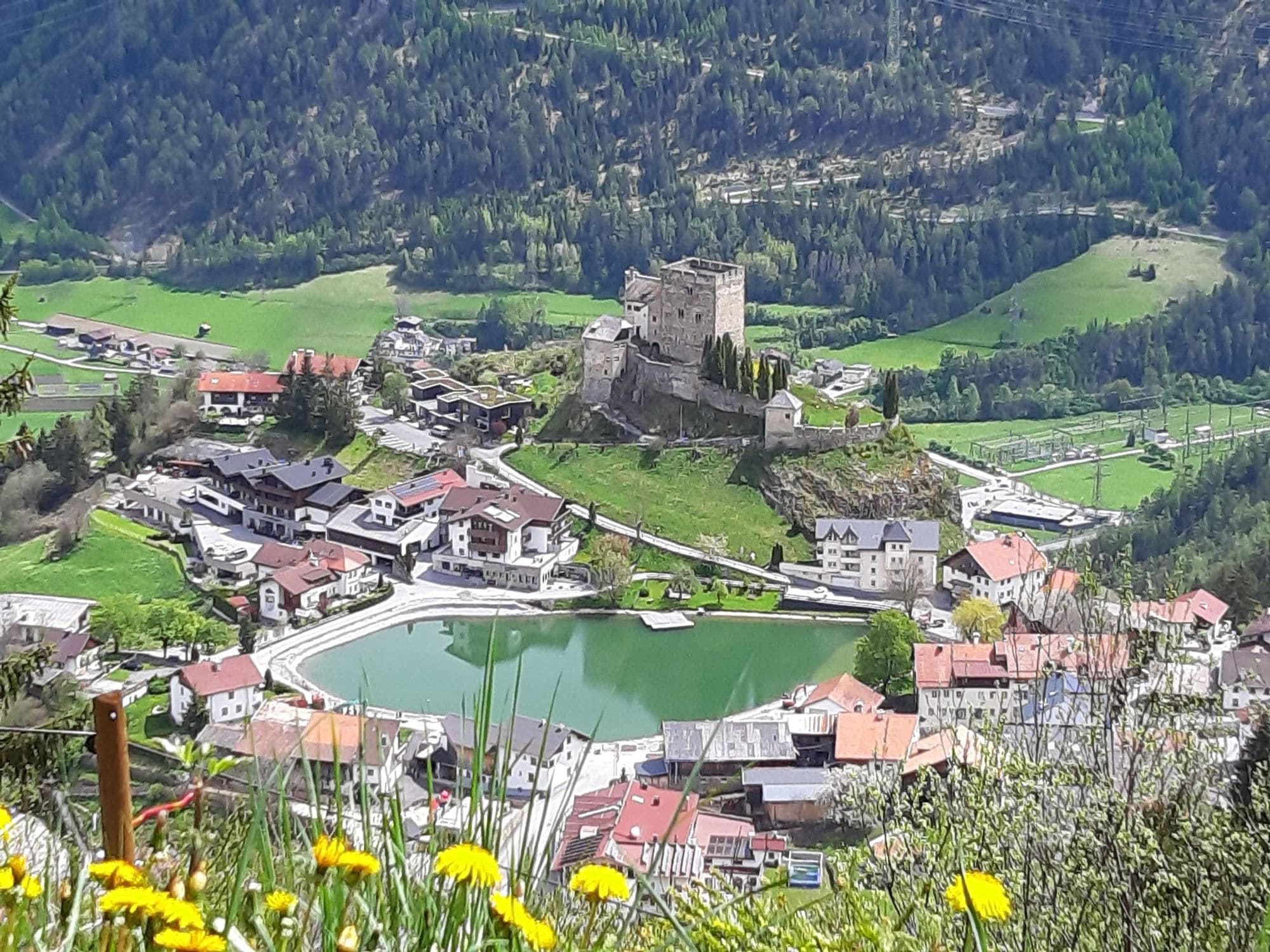 Frühlingsblick über Ladis mit Schloss Laudegg und Dorfsee vom Café Obladis
