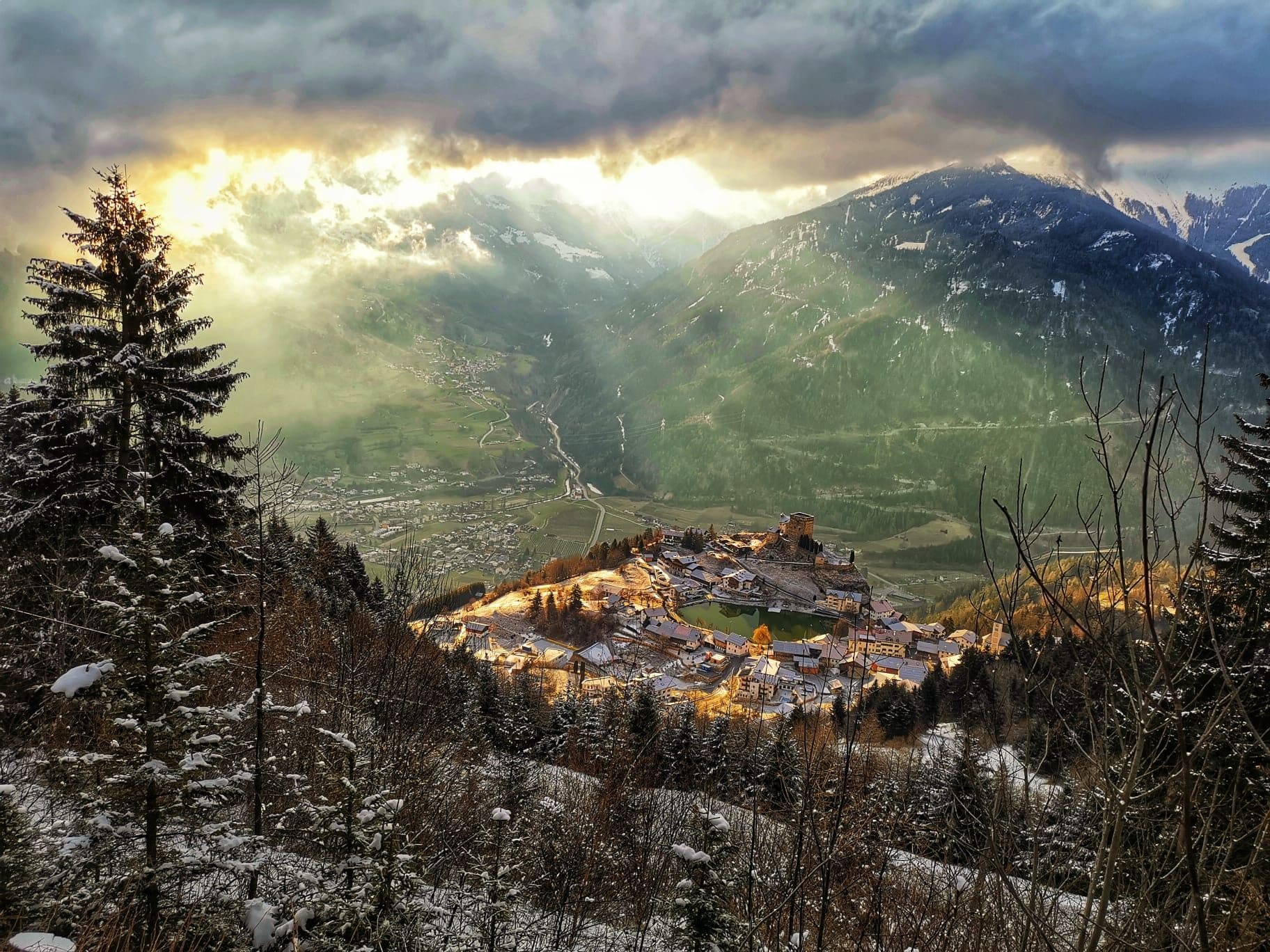Blick auf das Bergdorf Ladis mit Schloss Laudegg im Winterlicht über dem Tiroler Oberinntal