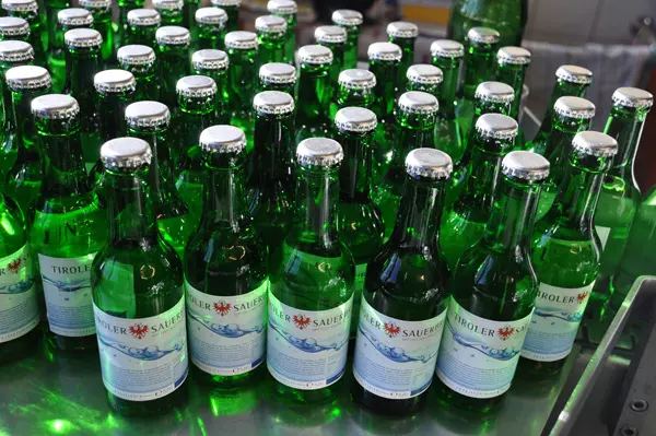Frisch verschlossene grüne Flaschen Tiroler Sauerbrunn nach der Abfüllung